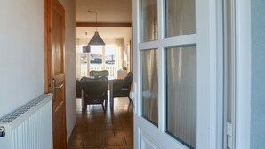 Un couloir comprenant un coin repas, un radiateur et une fenêtre à vitrage dépoli.