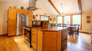 Eine Küche mit Holzausstattung, einem Edelstahlkühlschrank und einem eingebauten Backofen.