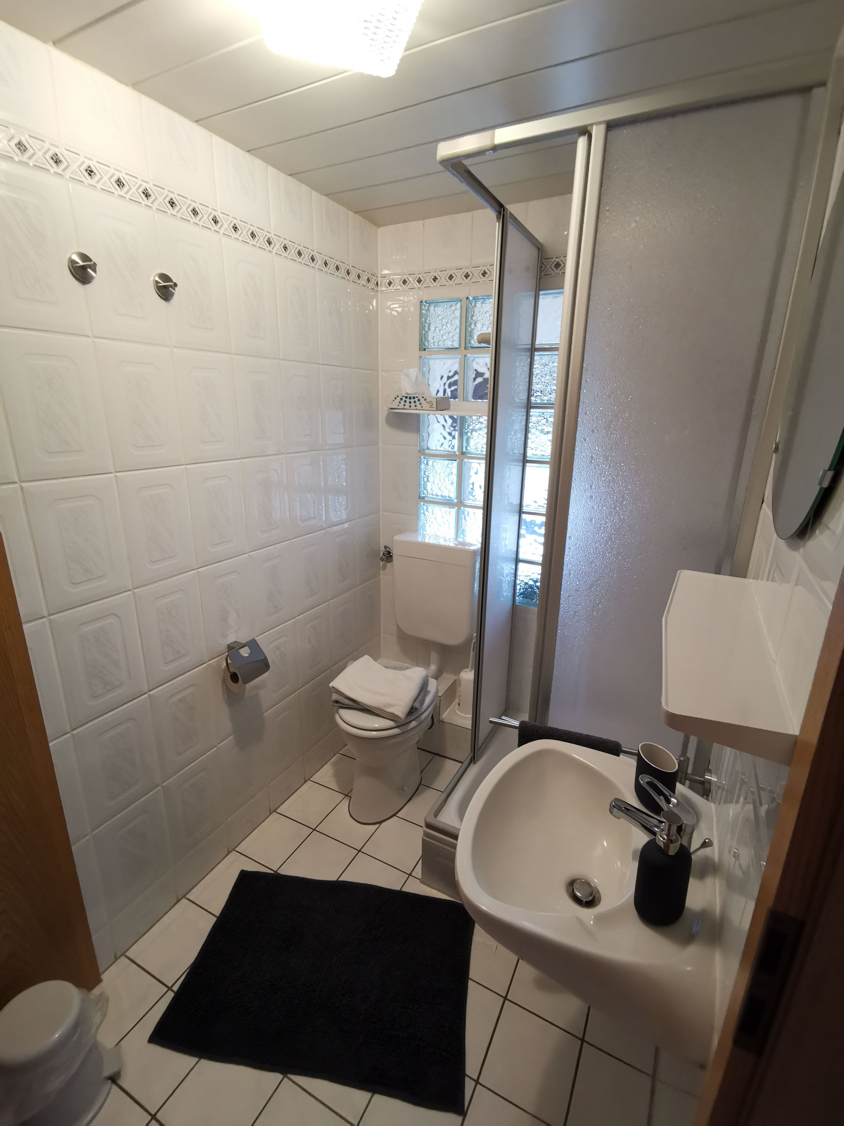 A bathroom with a toilet, sink, and shower.