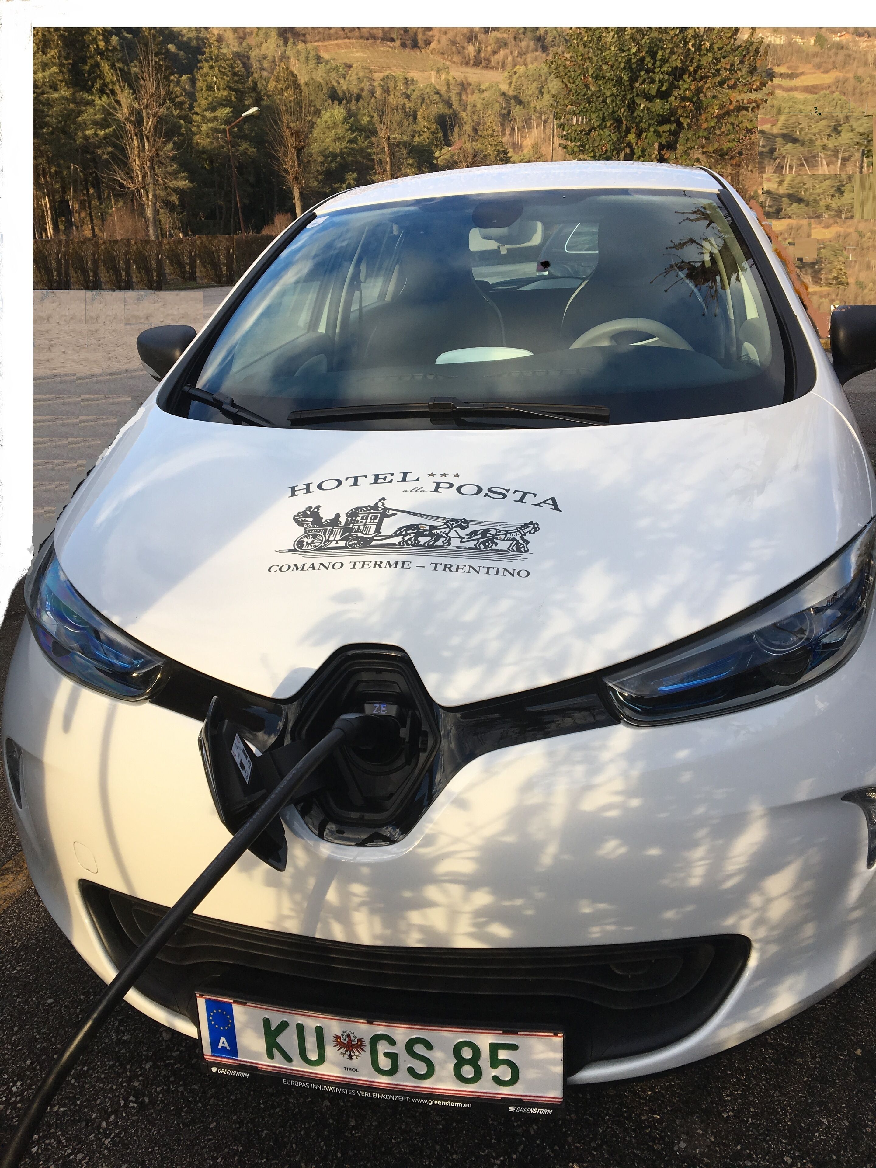 Ein weißes Auto mit dem Kennzeichen KU GS 85 steht in ländlicher Umgebung.