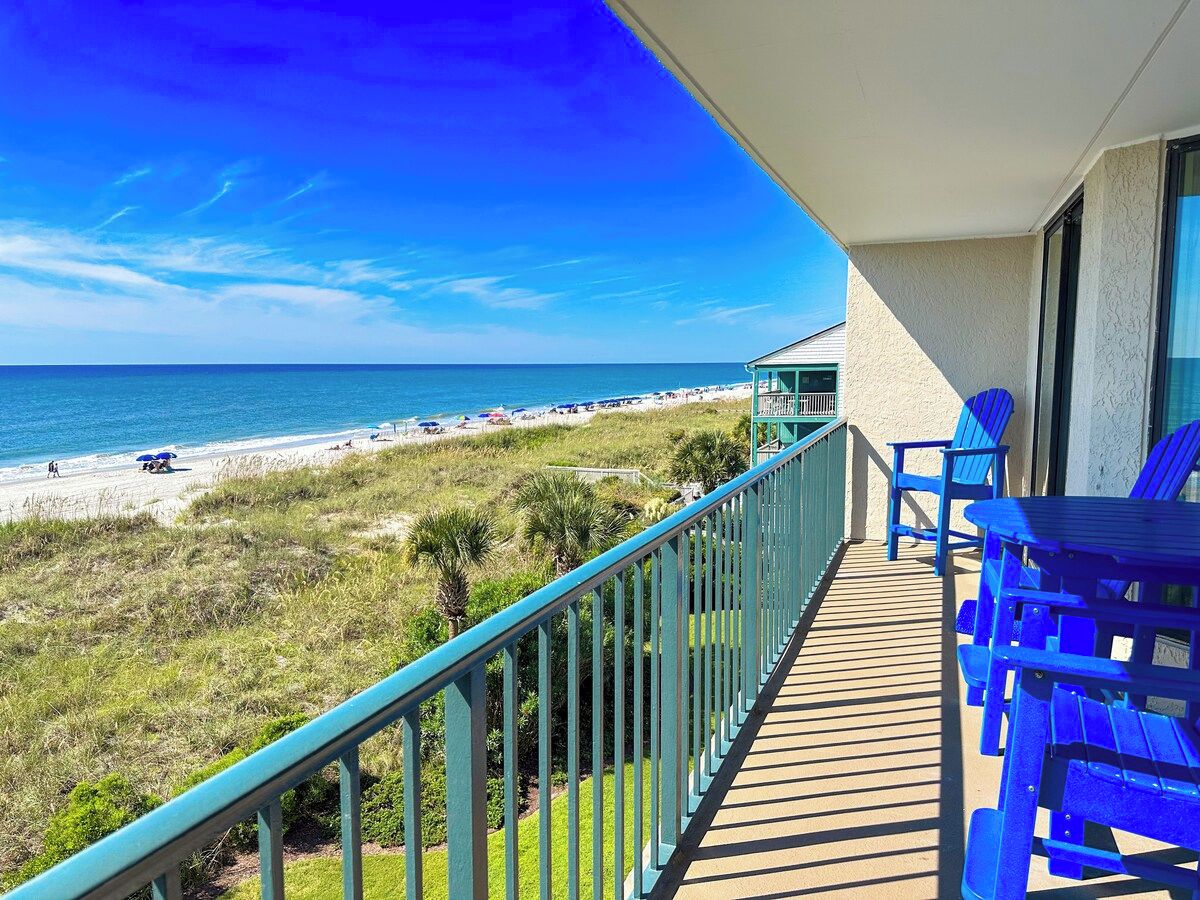 A balcony with a view of a beach and ocean.