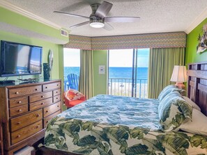 A bedroom with a bed, a dresser, a television, and a view of the ocean. - Beach Club I 3E (North Myrtle Beach)