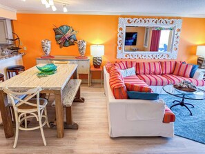 A living room with a sofa, a dining table with chairs, and a kitchen area in the background. - Beach Club I 3E (North Myrtle Beach)