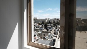 Una ventana con vista a un paisaje urbano, que incluye edificios y tejados.