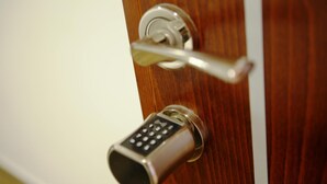 Una puerta con una cerradura electrónica moderna y una llave.