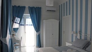 A bedroom with a bed, a wardrobe, a desk, and a chair.