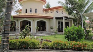 A two-story house with a circular central section and a flat roof. - Cabilao Sunset Dive & Beach Resort (Loon)