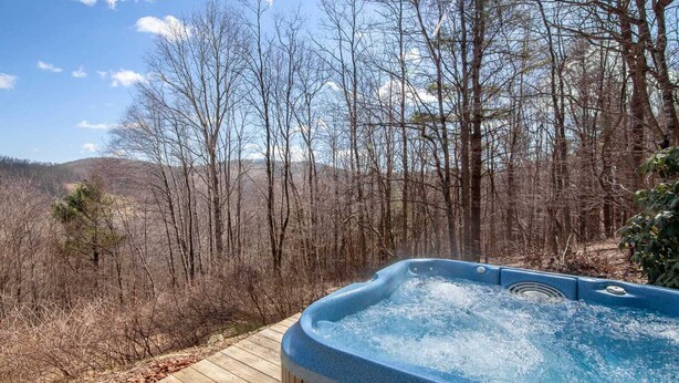 A hot tub on a wooden deck surrounded by a forested area with a mountain in the background. - Cozy 3BR Cabin w/ Long-Range Views, Hot Tub & Dog-Friendly (Todd)
