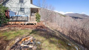 A two-story house with a porch, a hot tub, and a fire pit in the yard. - Cozy 3BR Cabin w/ Long-Range Views, Hot Tub & Dog-Friendly (Todd)
