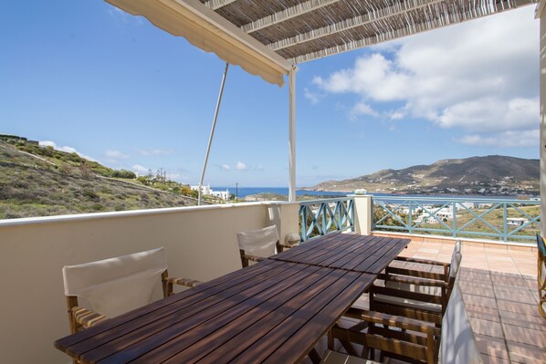 Enjoy a tranquil outdoor space with a table and chairs overlooking the coastal landscape.