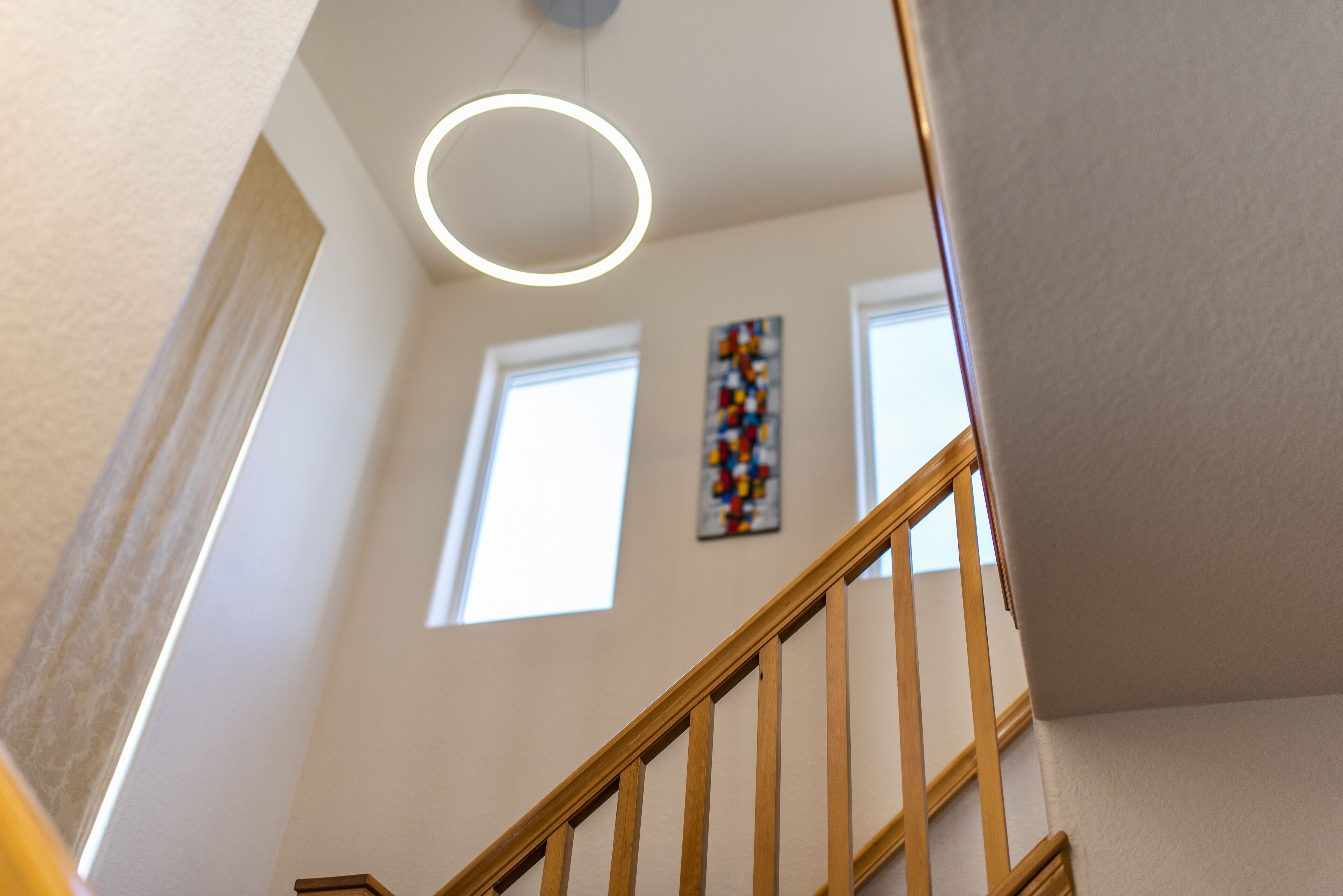 A staircase with wooden railings and a modern light fixture.