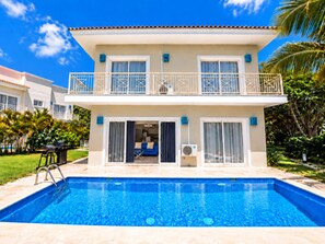 A two-story house with a swimming pool, a balcony, and a patio area.