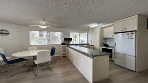 A compact kitchen with a dining area, a microwave, and a refrigerator. - 1 Edmund Shores 3-BR Kings Beach Apt w/ Pool (Kings Beach)