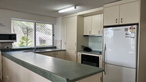 A kitchen with a microwave, sink, refrigerator, and cabinets. - 1 Edmund Shores 3-BR Kings Beach Apt w/ Pool (Kings Beach)