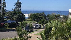 A residential street with a view of the ocean, parked cars, and lush greenery. - 1 Edmund Shores 3-BR Kings Beach Apt w/ Pool (Kings Beach)