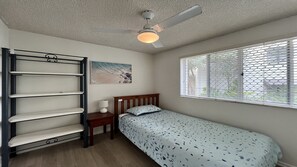 A bedroom with a bed, a nightstand, a wall-mounted shelf, a ceiling fan, and a window with blinds. - 1 Edmund Shores 3-BR Kings Beach Apt w/ Pool (Kings Beach)