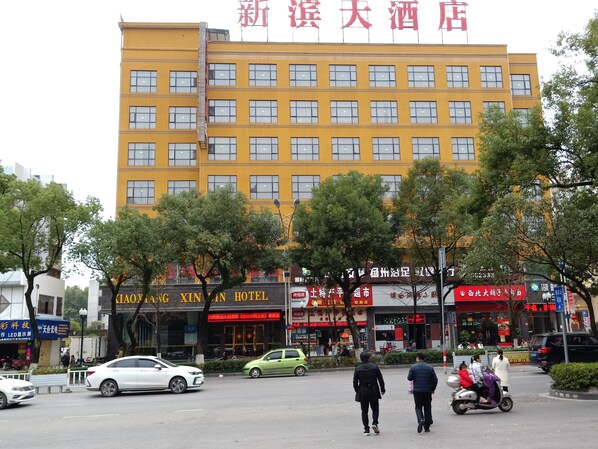 A multi-story hotel with a yellow facade and multiple windows. - Guilin Xin Bin International Hotel (Guilin)