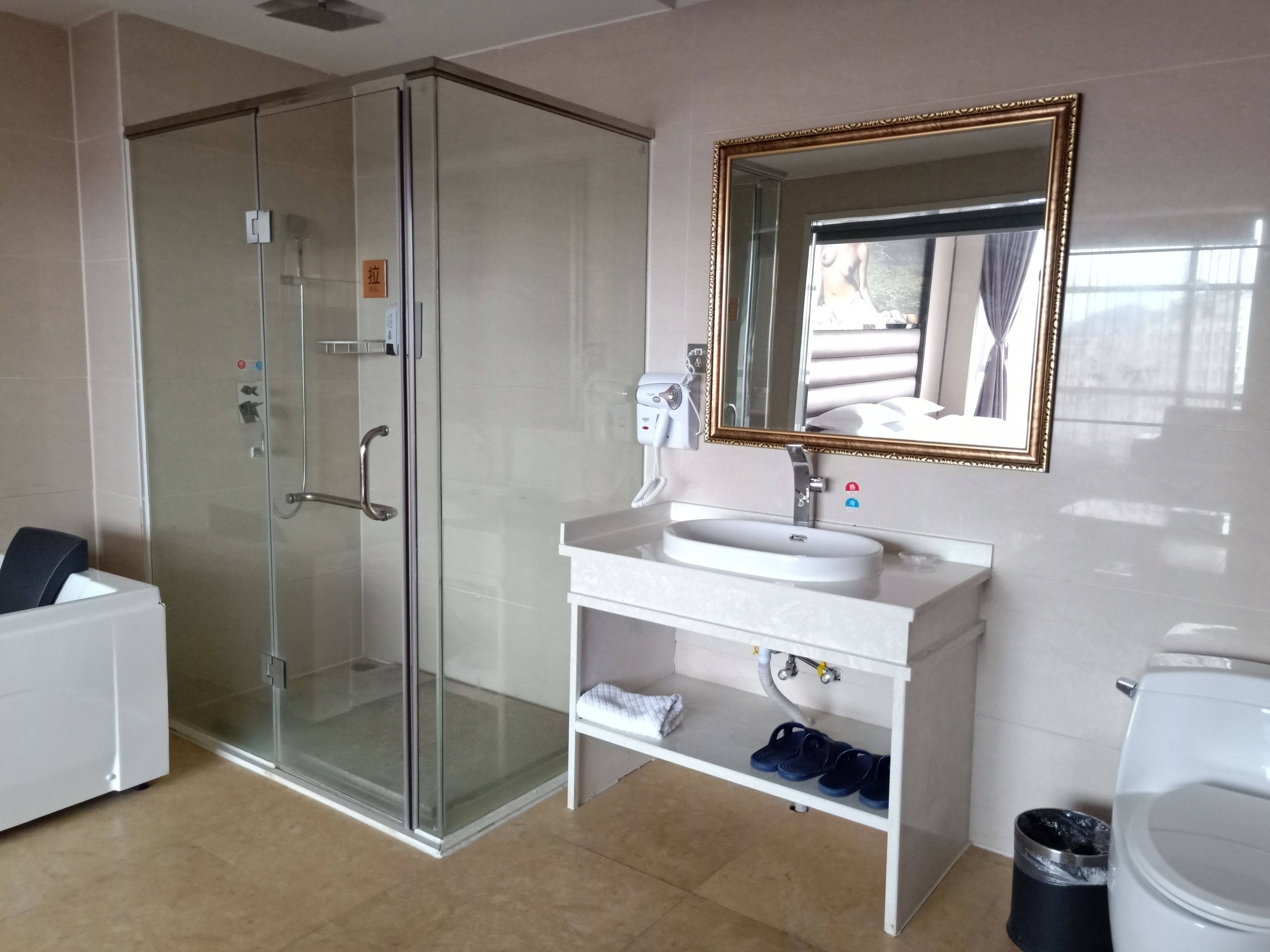 Un baño moderno con cabina de ducha de vidrio, un lavabo blanco con espejo y un inodoro blanco.