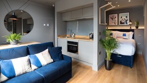 Un espace de vie moderne comprenant un canapé, une cuisine et un lit.