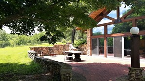 Un'area patio con un muro in pietra, un tavolo e una sedia.