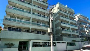 Un edificio residencial de varios pisos con balcones, una entrada a nivel de calle y una señalización visible que dice 'ED. RESIDENCIAL'.