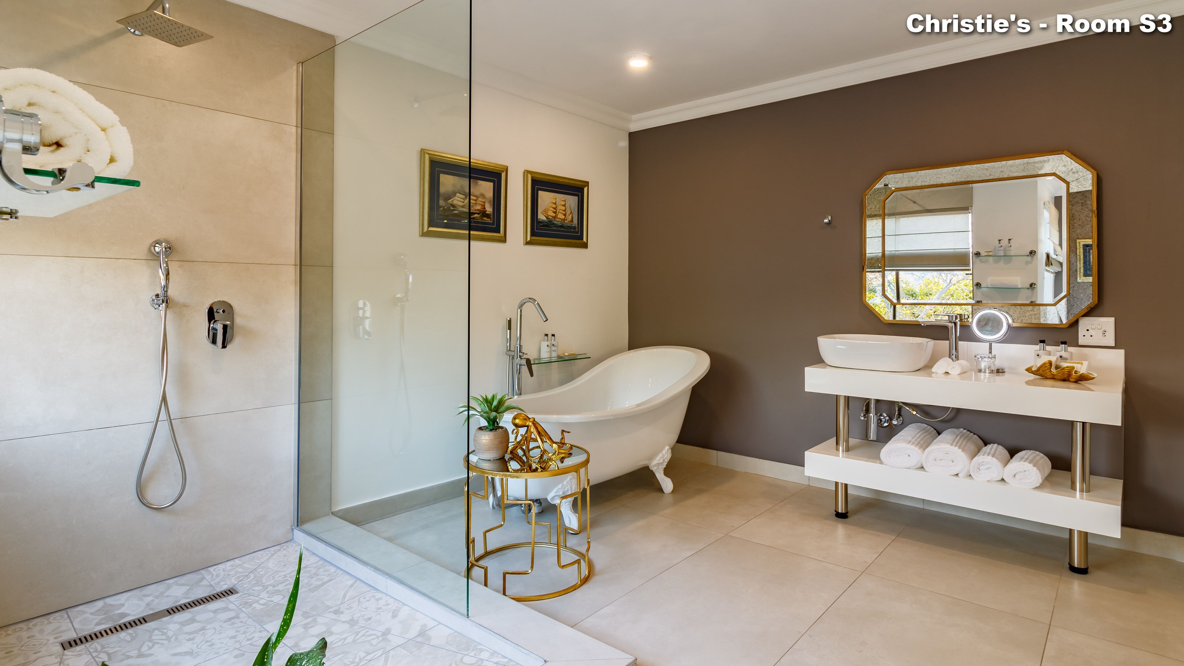 A modern bathroom with a freestanding bathtub, a glass-enclosed shower, and a vanity with a mirror and multiple sinks.