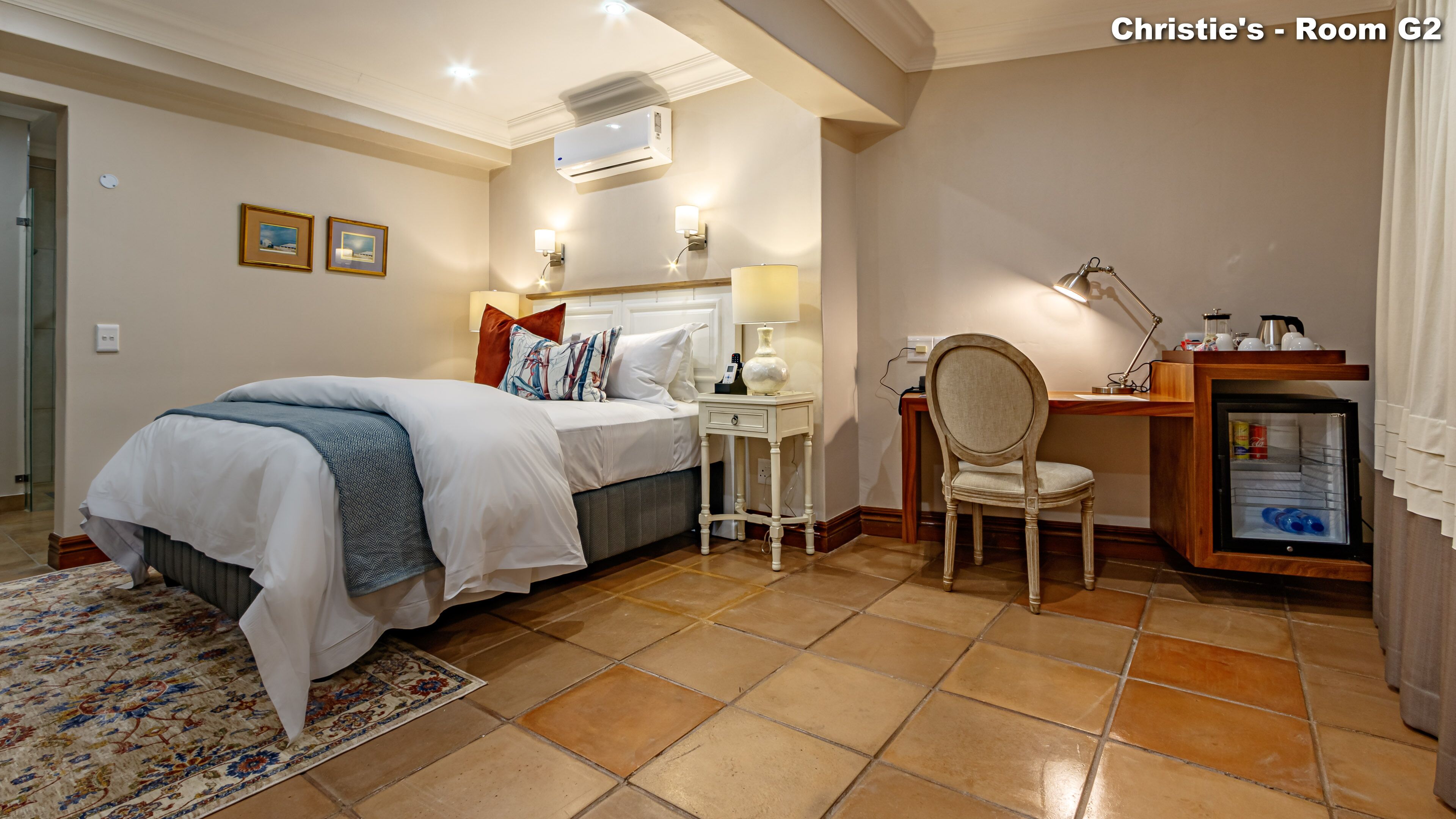Une chambre d’hôtel équipée d’un lit, d’une table de chevet, d’une chaise, d’un bureau et d’un mini-bar.