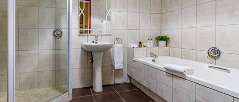 A modern bathroom with a shower, sink, and bathtub.