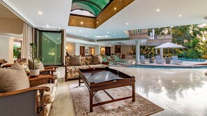 A spacious living area with a pool, comfortable seating, and a view of the outdoors. - Christie's at 32 on Russell (Mbombela)