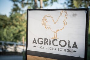 Un letrero con un gallo y los textos 'AGRICOLO', 'CASA CUCINA BOTTTEGA'.