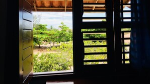 A room with a view of a vineyard through a wooden door with horizontal slats. - Residencial Bem Te Vi (Jijoca de Jericoacoara)