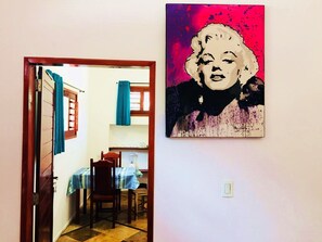 A room with a dining area, a door leading to another room, and a painting on the wall. - Residencial Bem Te Vi (Jijoca de Jericoacoara)