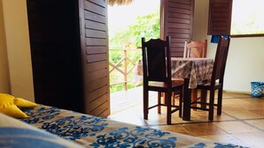 A room with a bed, a chair, and a table with a tablecloth. - Residencial Bem Te Vi (Jijoca de Jericoacoara)