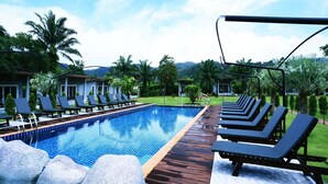 A swimming pool with lounge chairs, a wooden deck, and palm trees. - WELCOME TO KHAOLAK MOUNTAIN VIEW (Khuekkhak)
