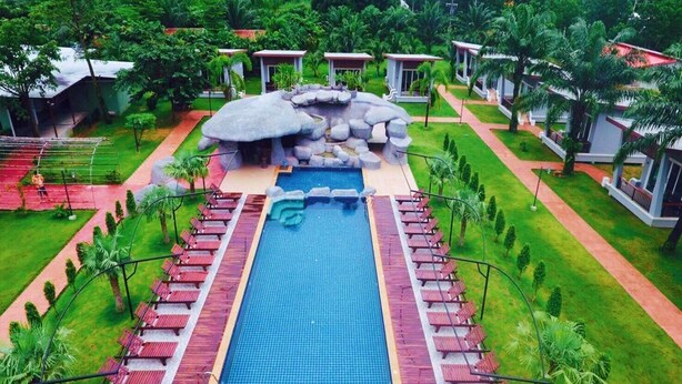 A resort with a central swimming pool, lounge chairs, and a rock formation. - WELCOME TO KHAOLAK MOUNTAIN VIEW (Khuekkhak)