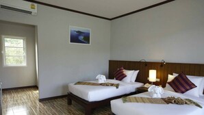 A hotel room with two beds, wooden headboards, a small bedside table with a lamp, and a framed picture on the wall. - WELCOME TO KHAOLAK MOUNTAIN VIEW (Khuekkhak)