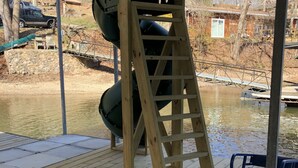 A wooden deck with a slide and a ladder.