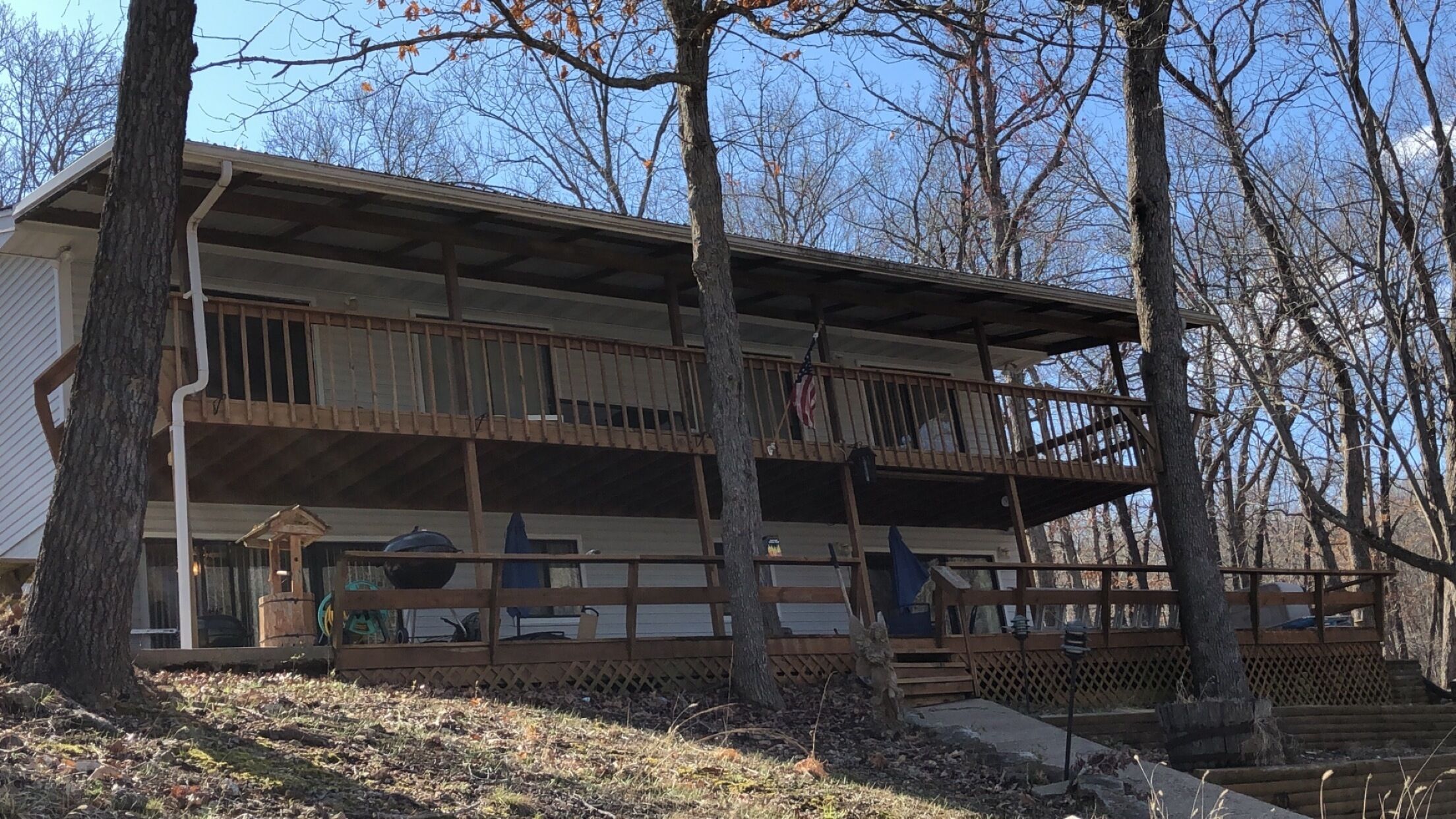 A two-story building with a covered porch and a fenced deck area.