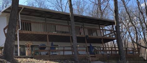 A two-story building with a covered porch and a fenced deck area.