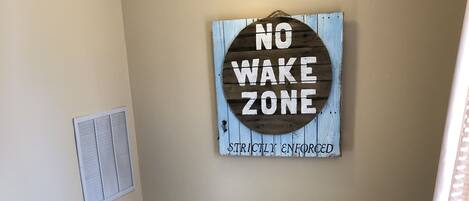 A staircase with a 'No Wake Zone' sign on the wall.