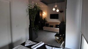 A modern living room with a sofa, a coffee table, and hanging lights. - Batroun Bahsa Bay (Batroun)