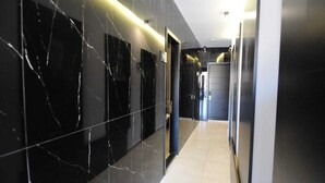 A modern hallway with black marble walls and a tiled floor. - Batroun Bahsa Bay (Batroun)