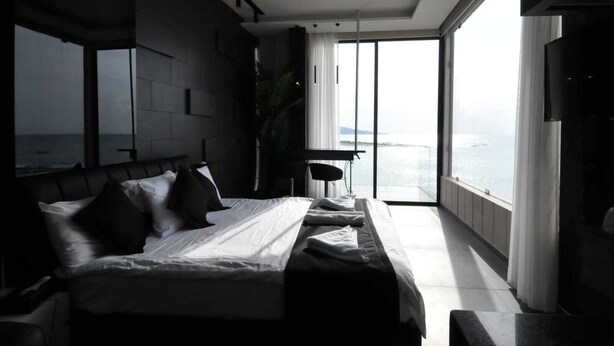 A modern bedroom with a large bed, a desk, and a view of the sea. - Batroun Bahsa Bay (Batroun)