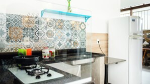 Una cocina con estufa a gas, un lavamanos y un refrigerador.