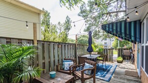 Una terraza de madera con mobiliario exterior, una mesa y sillas.