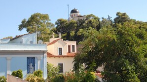 A building with a dome and a bell tower, surrounded by trees and other buildings. - Happy place at the foot of Acropolis. (Athens)