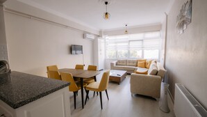Ein modernes Wohnzimmer mit einer Couch und einem Essbereich mit Tisch und Stühlen.