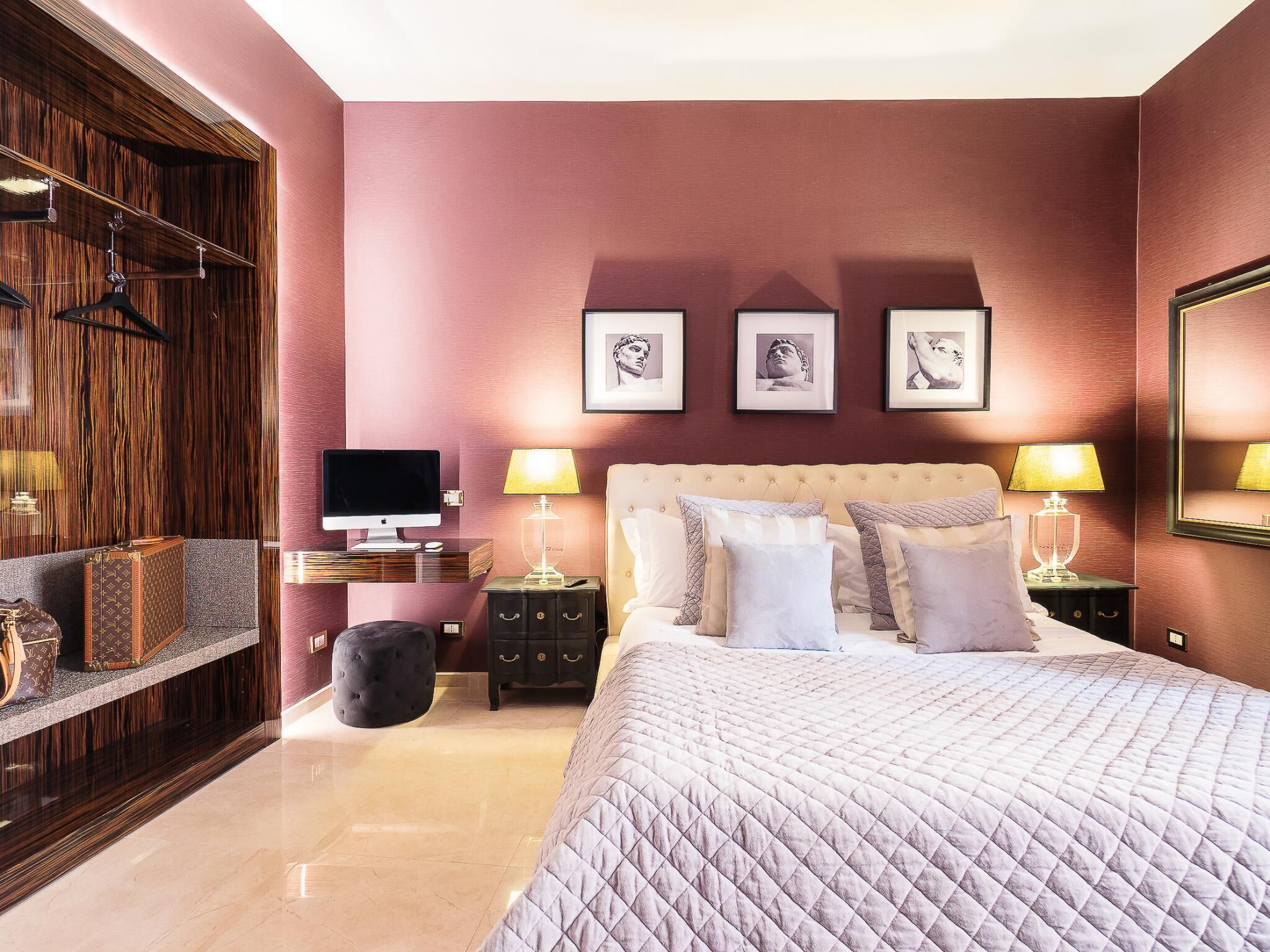 Um quarto com uma cama grande, uma escrivaninha com um computador e um guarda-roupa.