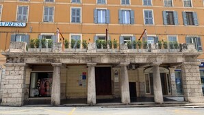 Un edificio con fachada amarilla, varias ventanas con contraventanas y un letrero que dice "APRESS".