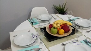 A dining table set with plates, cutlery, and a fruit bowl. - Mets Near From Panathenaic Kallimarmaro Stadium (Athens)
